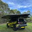 hardshell rooftop tent on black car with bushwakka branding with its boot open